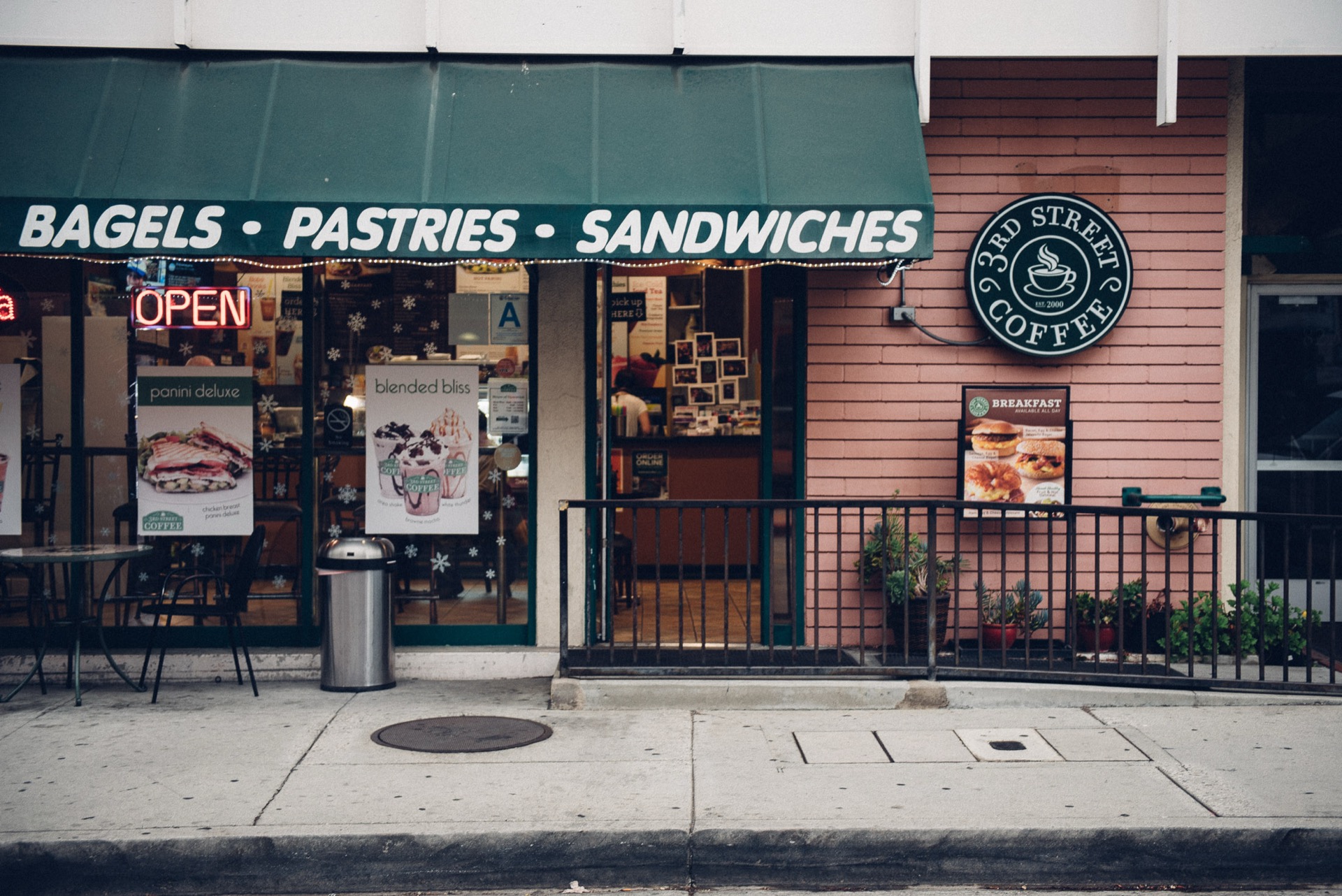 Close-up of 3rd Street Coffee's green awning, logo sign, and storefront